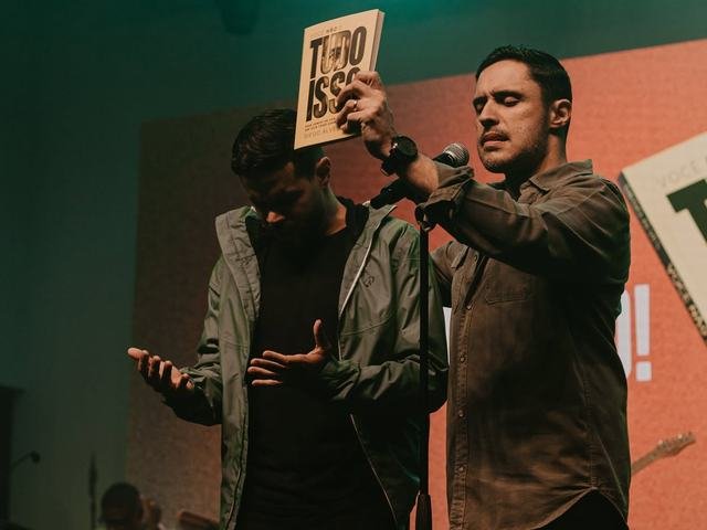 Diego Alves apresenta o livro no palco durante o lançamento.